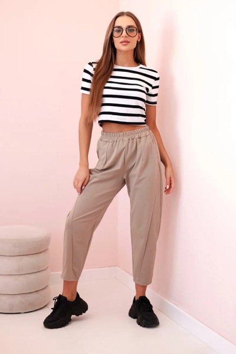 Modelka w spodniach w kolorze camel z elastycznym pasem – Stylowy Wieszak Modelka w spodniach w kolorze camel z elastycznym pasem – Stylowy Wieszak