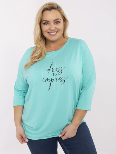 Modelka w turkusowej bluzce plus size RELEVANCE z napisem i dżetami