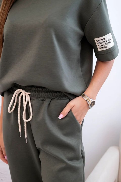 Modelka w khaki komplecie z wiskozy – bluzka z krótkim rękawem i spodnie z elastycznym pasem i ściągaczami Modelka w khaki komplecie z wiskozy – bluzka z krótkim rękawem i spodnie z elastycznym pasem i ściągaczami