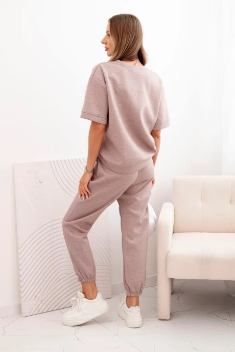 Modelka w komplecie damskim z wiskozy w odcieniu beżowego melanżu – luźna bluzka i spodnie z elastycznym pasem Modelka w komplecie damskim z wiskozy w odcieniu beżowego melanżu – luźna bluzka i spodnie z elastycznym pasem