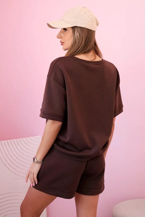 Modelka w brązowym komplecie z luźną bluzką i szortami z wysokim stanem – stylowa, sportowa stylizacja na lato Modelka w brązowym komplecie z luźną bluzką i szortami z wysokim stanem – stylowa, sportowa stylizacja na lato