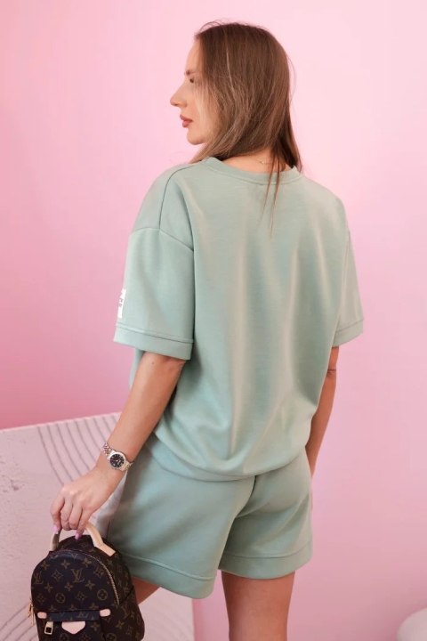 Modelka w ciemno miętowym komplecie z wiskozy – bluzka z nadrukiem i szorty z wysokim stanem Modelka w ciemno miętowym komplecie z wiskozy – bluzka z nadrukiem i szorty z wysokim stanem