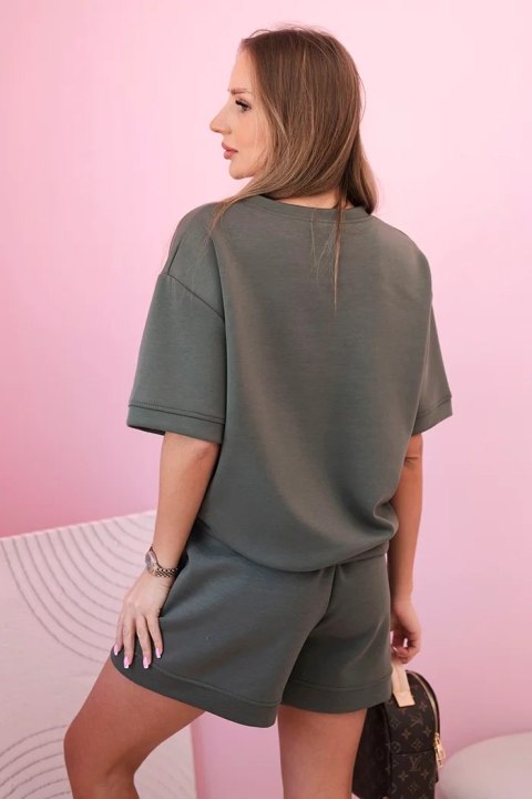 Modelka w khaki komplecie z krótkim rękawem i szortami – codzienna stylizacja w modnym kolorze Modelka w khaki komplecie z krótkim rękawem i szortami – codzienna stylizacja w modnym kolorze