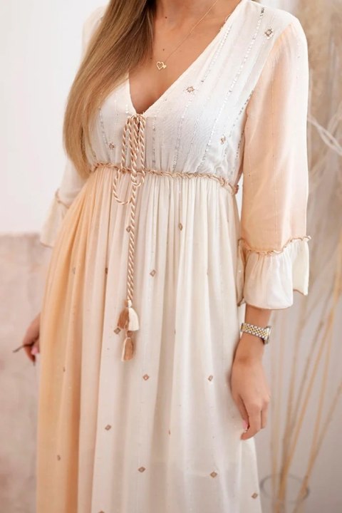 Modelka w beżowej sukience boho z wiskozy, zdobionej cekinami i ozdobnym wiązaniem – stylizacja na lato Modelka w beżowej sukience boho z wiskozy, zdobionej cekinami i ozdobnym wiązaniem – stylizacja na lato