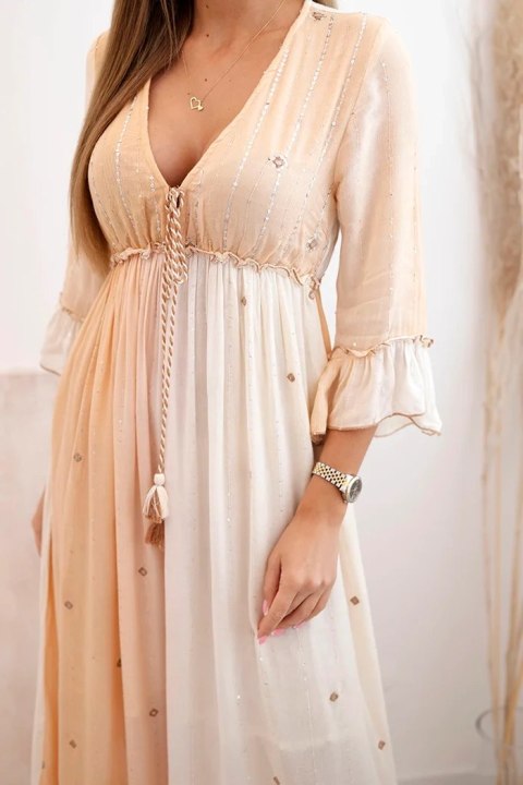 Modelka w morelowej sukience boho z wiskozy, zdobionej frędzlami i cekinami – stylizacja na lato Modelka w morelowej sukience boho z wiskozy, zdobionej frędzlami i cekinami – stylizacja na lato