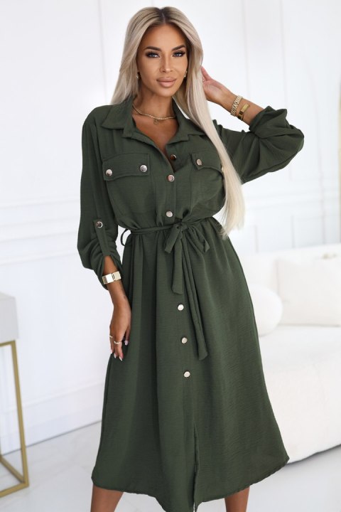 Kobieta w khaki szmizjerce midi z wiązaniem w talii i złotymi guzikami, modna stylizacja casual Kobieta w khaki szmizjerce midi z wiązaniem w talii i złotymi guzikami, modna stylizacja casual
