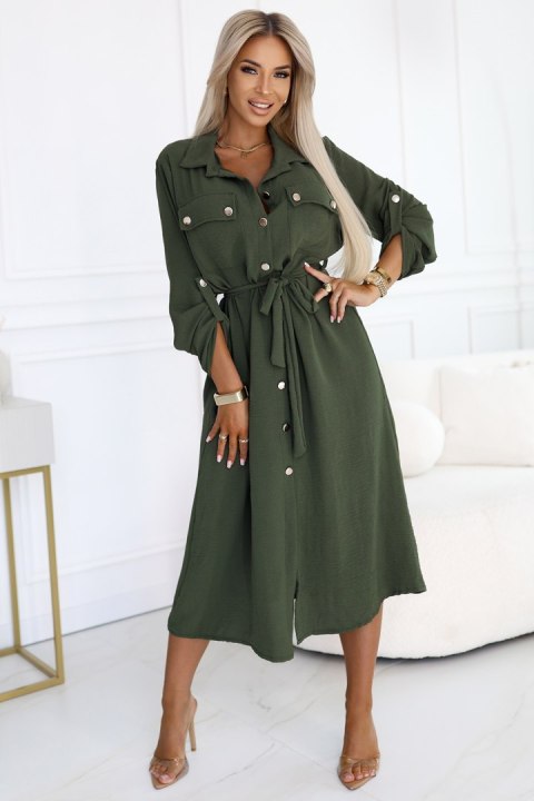 Kobieta w khaki szmizjerce midi z wiązaniem w talii i złotymi guzikami, modna stylizacja casual Kobieta w khaki szmizjerce midi z wiązaniem w talii i złotymi guzikami, modna stylizacja casual