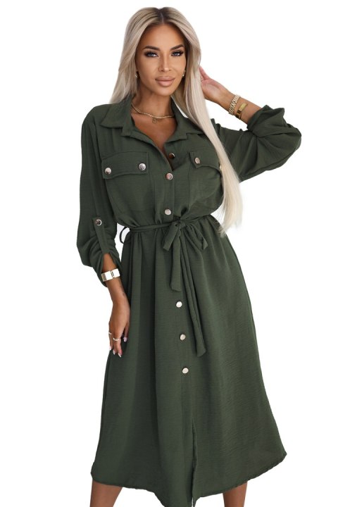Kobieta w khaki szmizjerce midi z wiązaniem w talii i złotymi guzikami, modna stylizacja casual Kobieta w khaki szmizjerce midi z wiązaniem w talii i złotymi guzikami, modna stylizacja casual