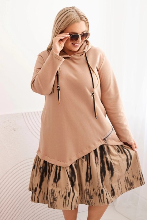 Sukienka damska Plus Size camelowa z kapturem i falbaną, bawełniana, modelka w modnej stylizacji casual