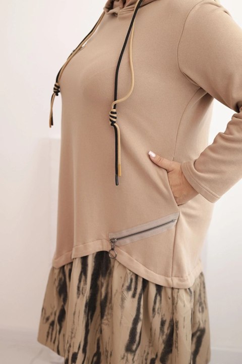 Sukienka damska Plus Size camelowa z kapturem i falbaną, bawełniana, modelka w modnej stylizacji casual