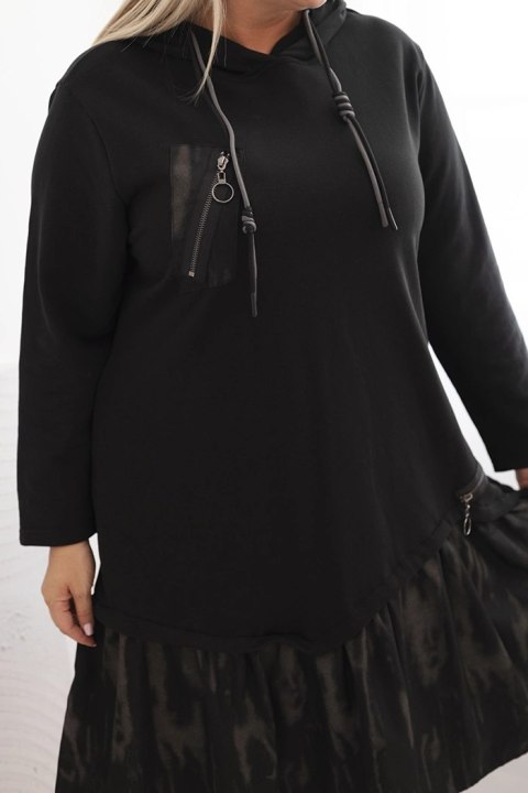 Sukienka damska Plus Size czarna z kapturem i falbaną, bawełniana, modelka w stylizacji casual