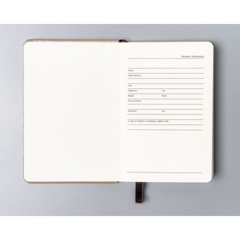 Beżowy notes w formacie A6 zadrukowany w linie, wyposażony w gumkę zamykającą - Peterson