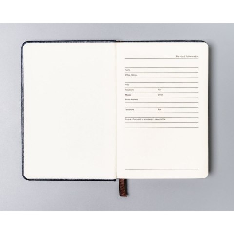 Notes w formacie A6 w szarym kolorze, zadrukowany w linie i wyposażony w gumkę zamykającą - Peterson