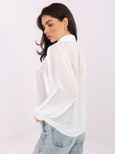 Modelka w białej koszuli z plisowaniem i ozdobnym wiązaniem