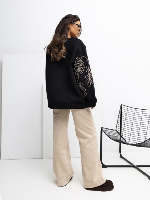 Modelka w czarnej bluzie kangurce oversize z haftem RUE PARIS