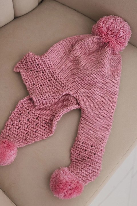 Pompony przy bokach różowej czapki damskiej zimowej