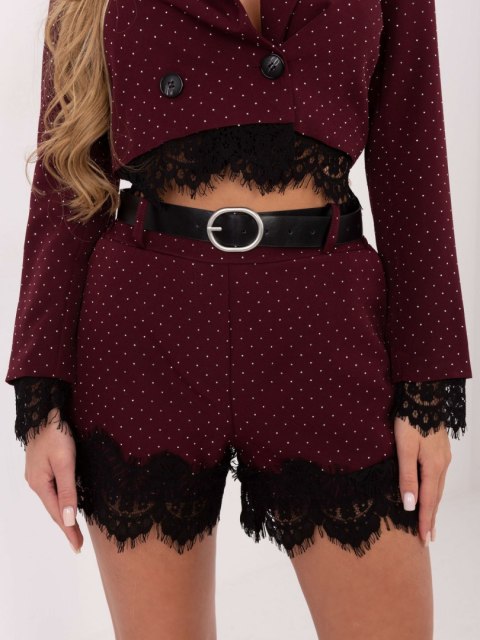 Detal srebrnych aplikacji i koronkowego wykończenia w damskich szortach