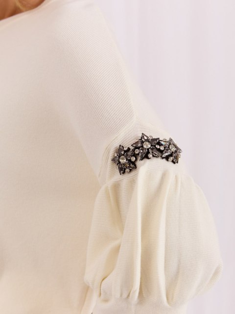 Sweter ecru damski z biżuteryjnymi zdobieniami na rękawach