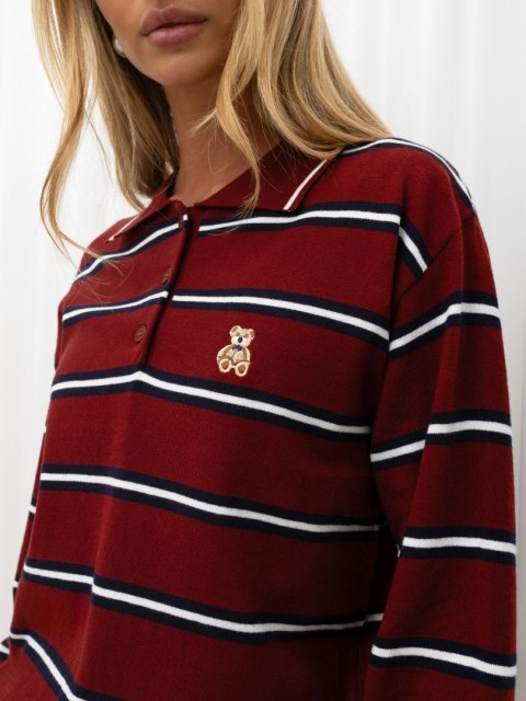 Zbliżenie na haftowanego misia, kołnierzyk i trzy guziki bordowego swetra polo w paski ITALY MODA.