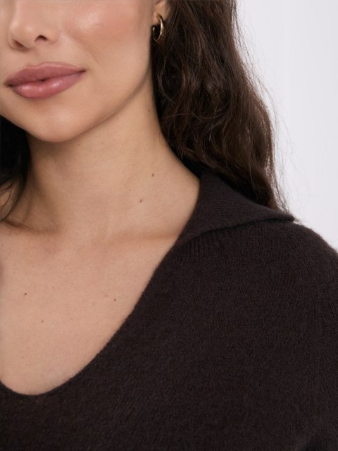 Zbliżenie na kołnierzyk, dekolt i puszystą dzianinę ciemnobrązowego swetra ITALY MODA.